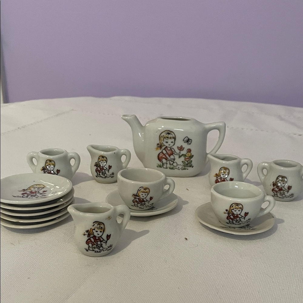 Children's miniature Tea Set with little girl holding flower image